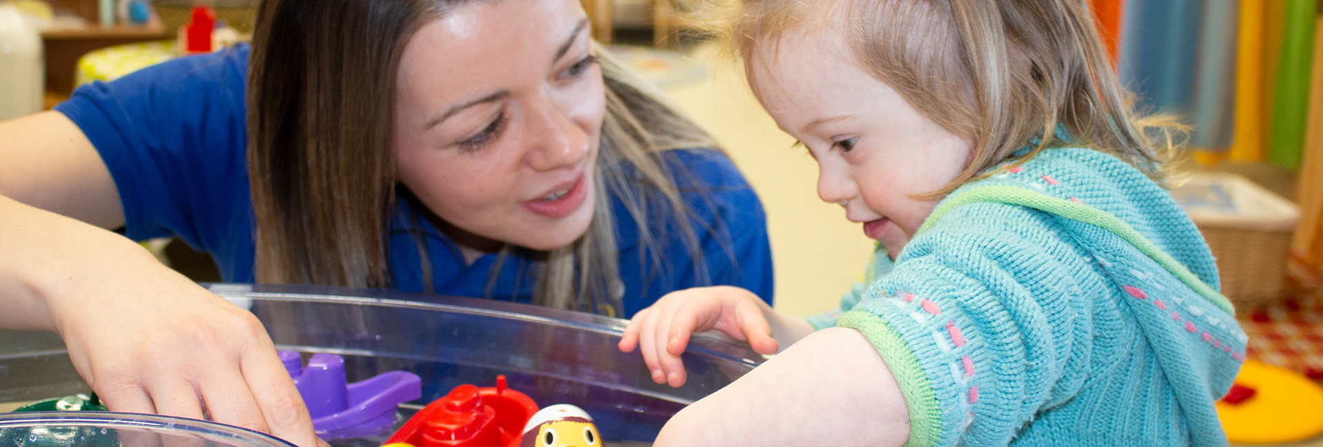Child Care Early Learning Years - Small girl and MI Student playing with toys