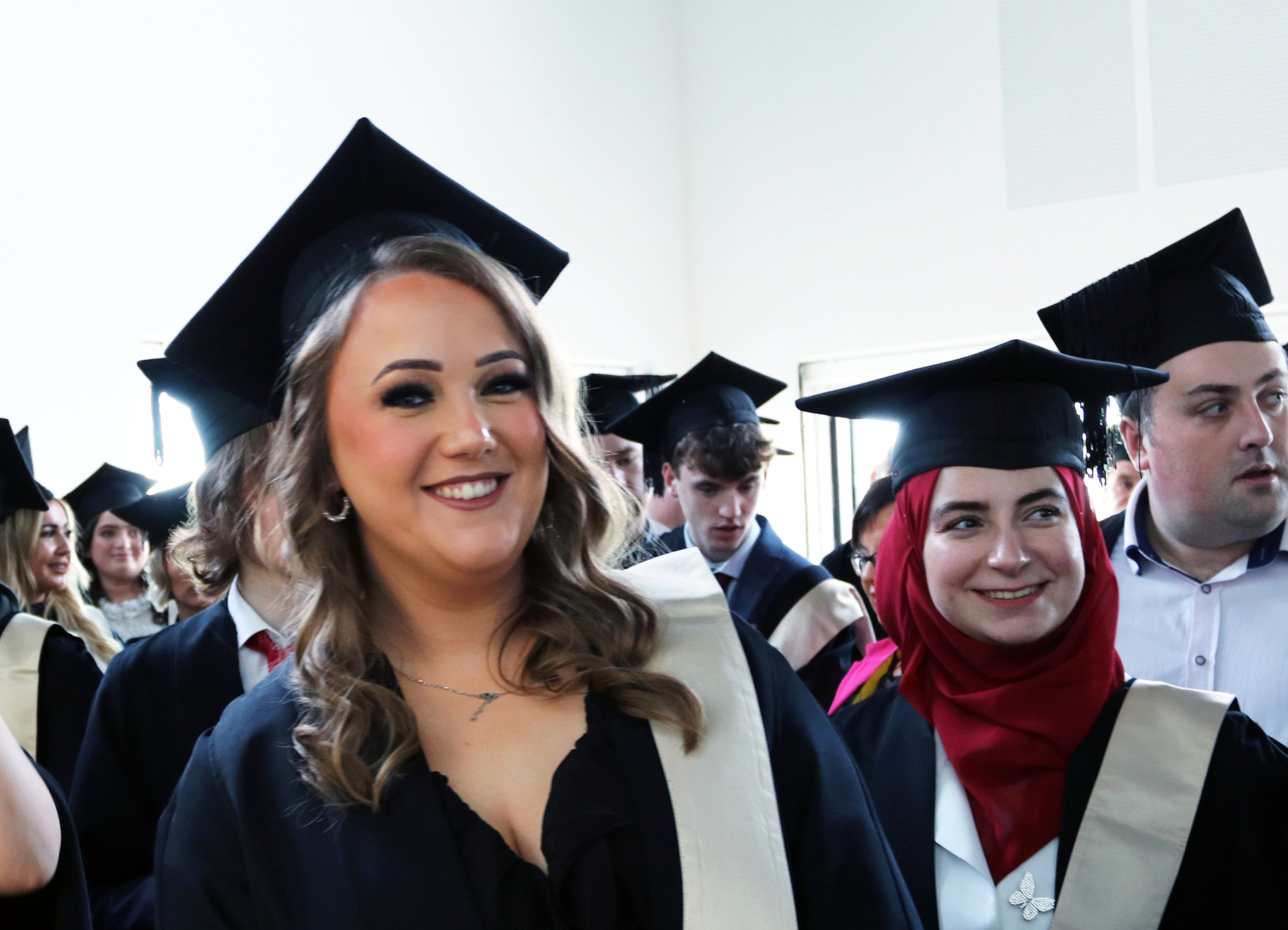 Graduation students with cap and gowns on smiling