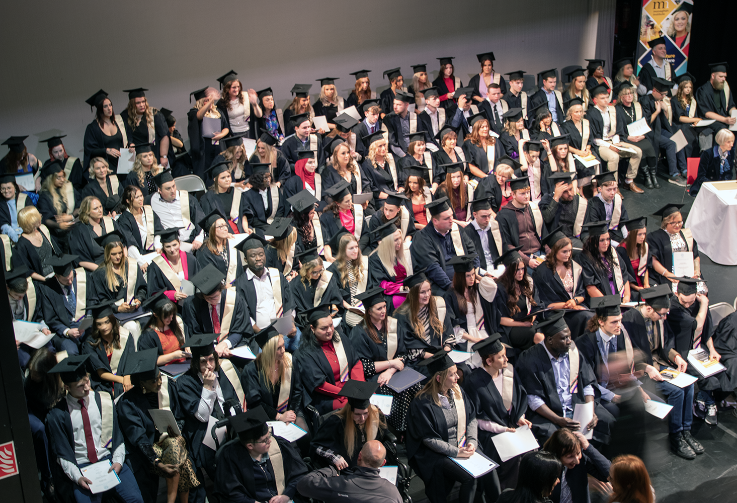 Graduation students sitting with cap and gowns on