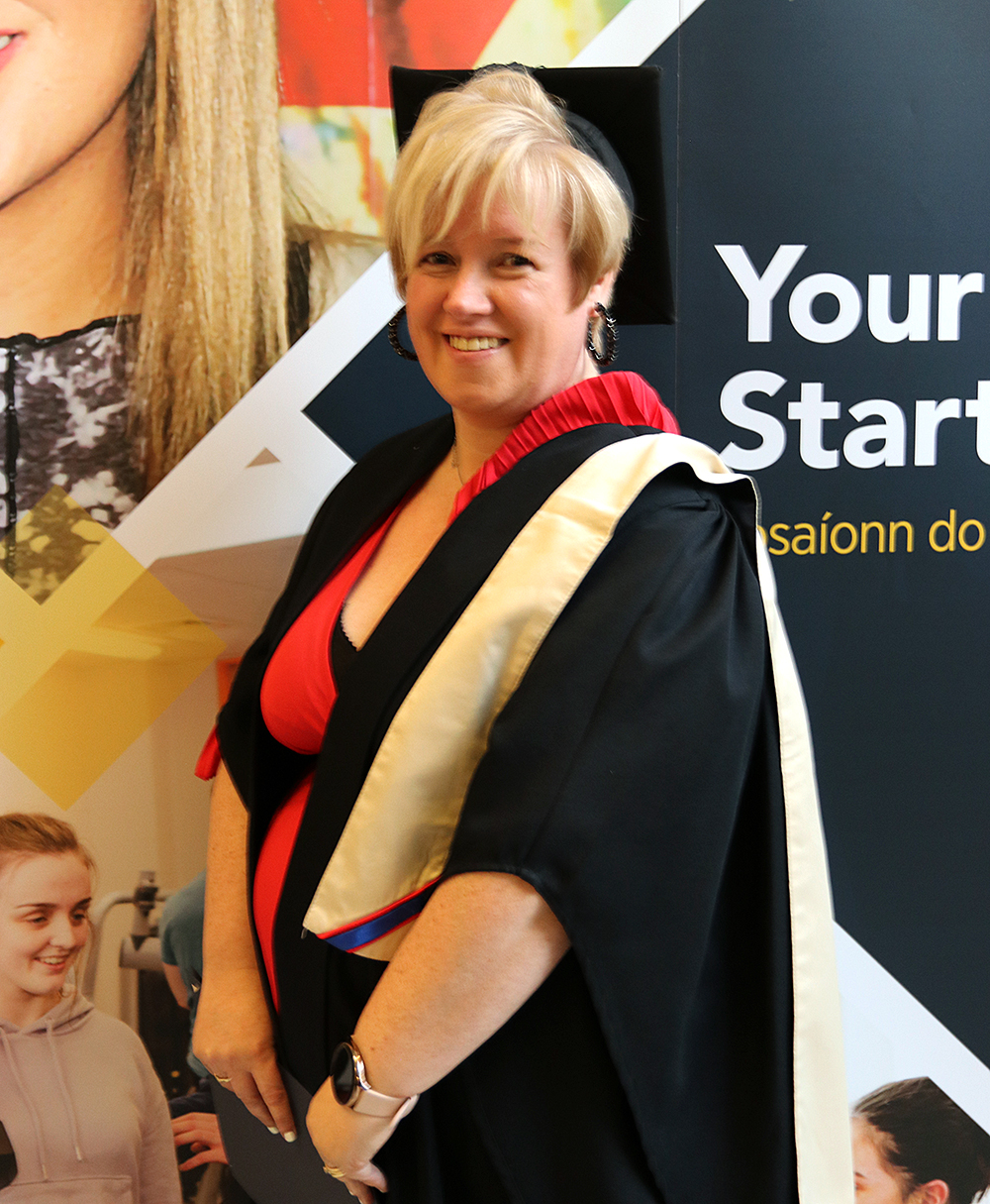 Woman with gown standing side ways smiling