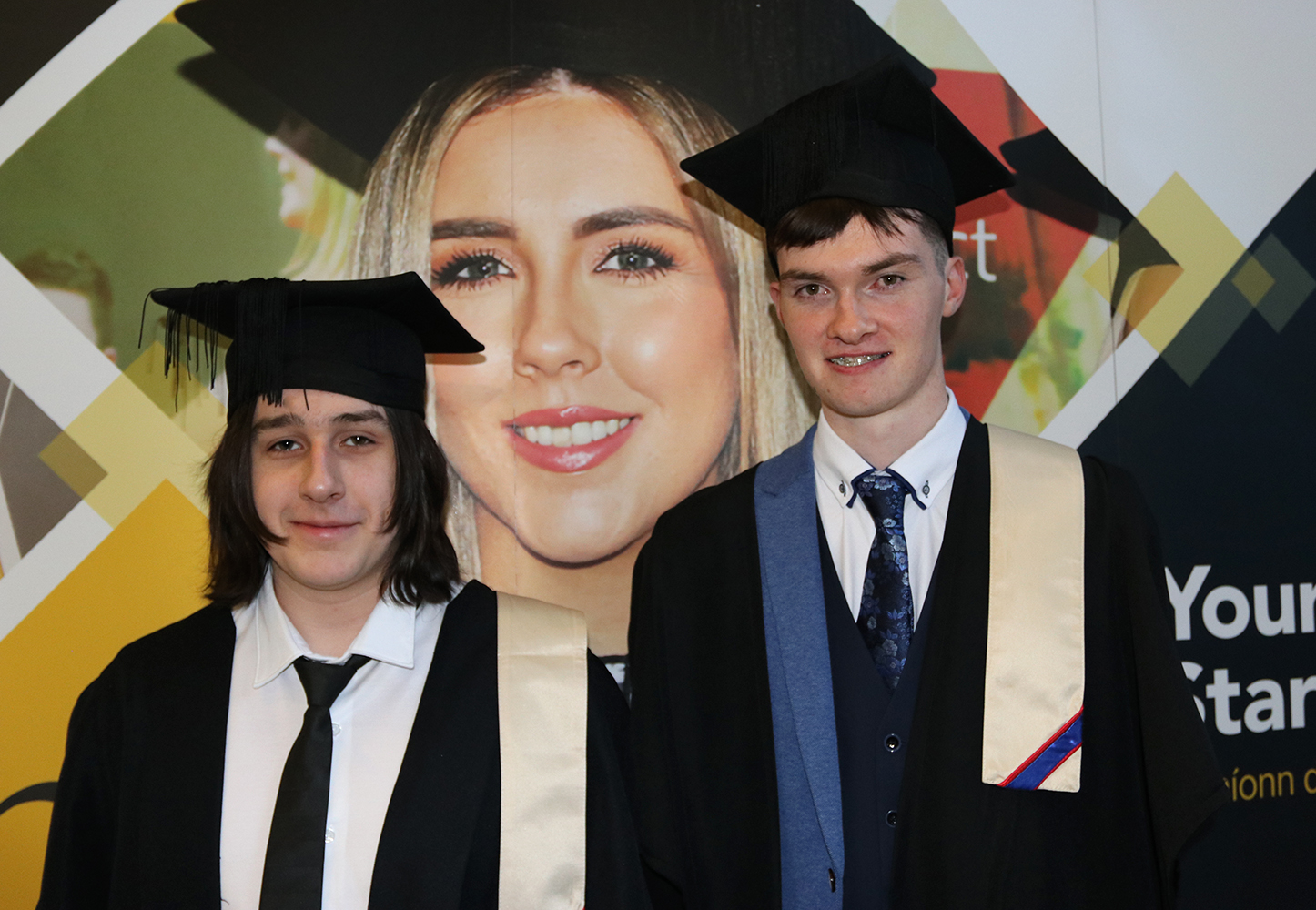 Two Students with cap and gown smiling