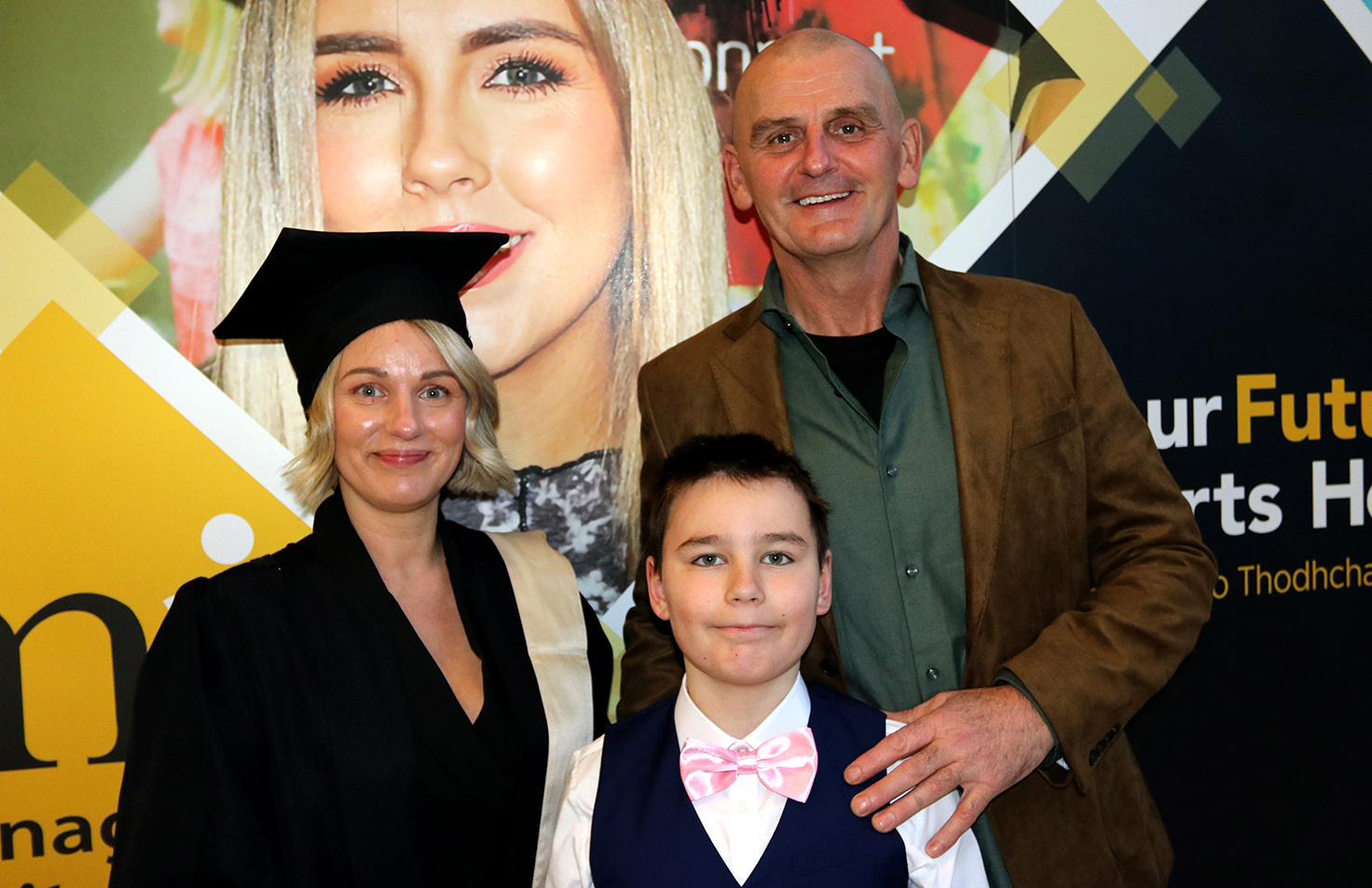 Student with cap and gown with family