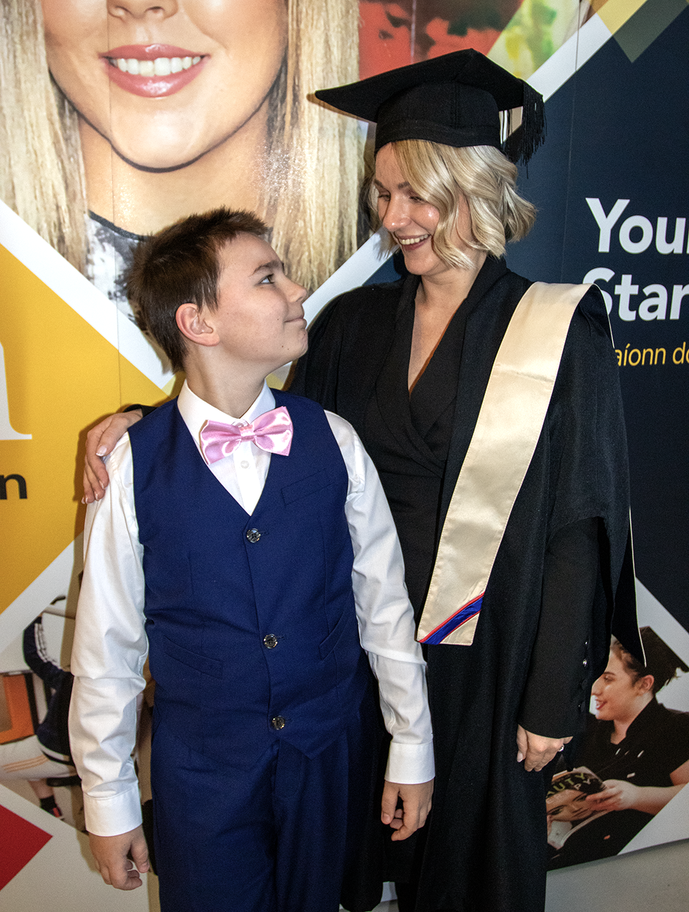 Student with cap and gown with family