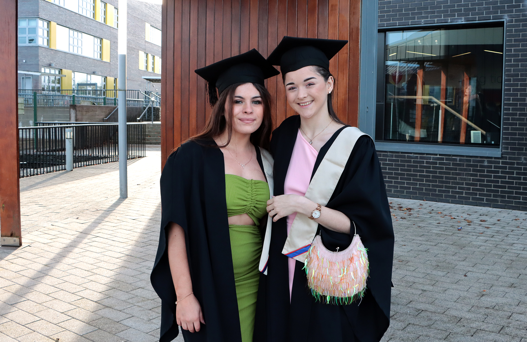 Two students standing with cap and gowns